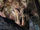 Stalactites and stalagmites in a cave with colorful lighting