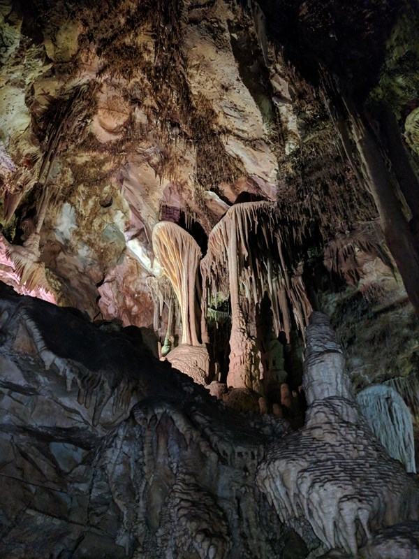 Stalactites and stalagmites in a cave with colorful lighting